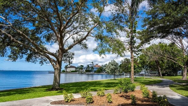 A waterfront park with trees, a walking path, and a body of water. - •Cozy•3BR•SRQ•Walk To Ringling•Near Beach•Peacocks (Sarasota)