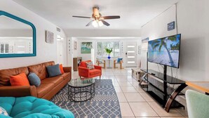 A living room with a sofa, armchair, coffee table, TV, and ceiling fan. - •Cozy•3BR•SRQ•Walk To Ringling•Near Beach•Peacocks (Sarasota)
