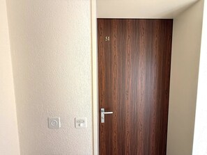 A door with a number '51' and a wall with two switches. - Royal 51 # 4-bed apartment, Bad, WC 4-Bettwohnung, Bad, WC by Interhome (Leukerbad)