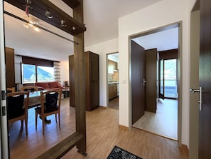 A modern interior with a dining area, kitchen, and a view of the outdoors. - Royal 51 # 4-bed apartment, Bad, WC 4-Bettwohnung, Bad, WC by Interhome (Leukerbad)