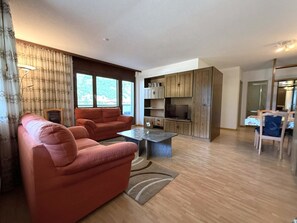 A modern living room with a sofa, a coffee table, and a TV. - Royal 51 # 4-bed apartment, Bad, WC 4-Bettwohnung, Bad, WC by Interhome (Leukerbad)