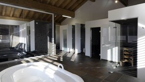A modern interior with a hot tub, wooden beams, and a glass partition. - Residenz Iris Leukerbad # 4-bed apartment, Dusche und Bad, WC by Interhome (Leukerbad)