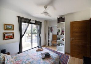 A bedroom with a bed, a window with curtains, a bookshelf, and a wardrobe. - Room "Chambre 3" with Mountain View, Shared Pool and Wi-Fi (Aléria)