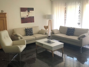 A modern living room with two sofas, a coffee table, and a floor lamp. - Edelweiss A 11 # 4-bed apartment, Dusche, WC 4-Bettwohnung, Dusche, WC by Interhome (Leukerbad)