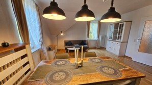Ein Essbereich mit Holztisch, schwarzen Stühlen und Pendelleuchten.