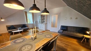 Ein Loft mit Essbereich, zwei Sofas und einer Küche.