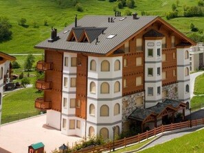 Ein mehrgeschossiges Hotel mit Innenhof, Balkonen und einer Steinaußenfassade.