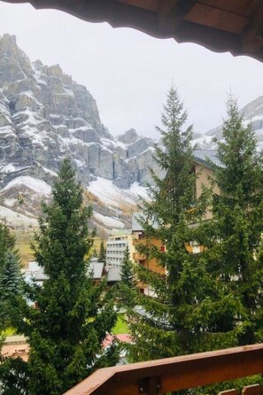 A mountainous landscape with snow-covered peaks and a building with multiple windows in the foreground. - Edelweiss A 31 # 4-bed apartment, Dusche und Bad, WC by Interhome (Leukerbad)