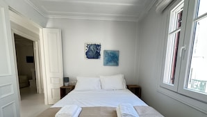 A bedroom with a bed, two nightstands, a window, and two wall art pieces. - Sapfous 10 (Lefkada)