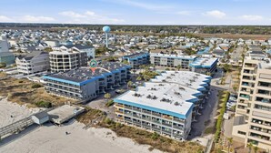 A coastal hotel with multiple buildings, a water tower, and a beach area.
