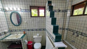 A bathroom with a sink, toilet, and a small window. - Costa Rican Paradise (La fortuna)