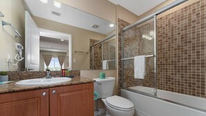 Un baño con lavamanos, inodoro y ducha.