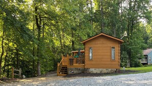 Eine kleine Holzhütte mit Veranda, Briefkasten und einem Schotterweg.