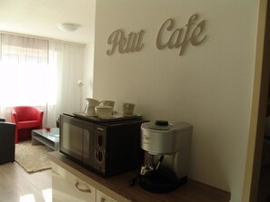 A kitchenette area with a coffee maker, a microwave, and a cabinet. - Clabina 19 # 4-bed apartment, Bad, WC 4-Bettwohnung, Bad, WC by Interhome (Leukerbad)