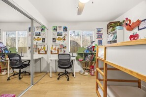 A room with a desk, two chairs, a bunk bed, and various wall decorations. - Cozy Highland Park Family Home w/ EV (Los Angeles)