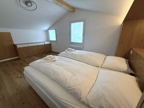 Eine kleine Einzimmerwohnung mit zwei Betten, einem Fenster und einer Heizung.