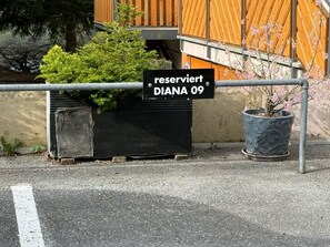 Un área cerrada con un letrero que dice 'reserviert DIANA 09' y una planta en maceta a un lado.