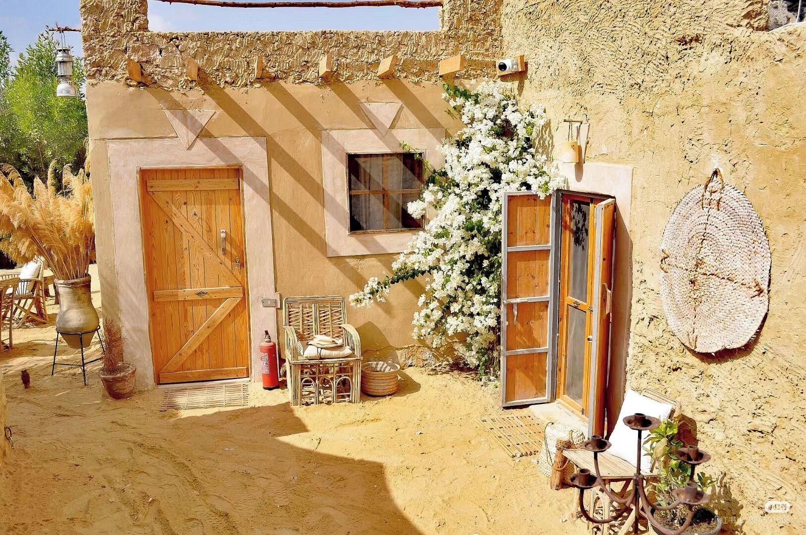 Un edificio rustico con una porta di legno, una finestra e un faretto a parete.