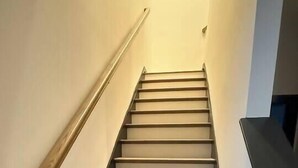 A staircase with wooden steps and a metal handrail. - Upscale 3BR Townhome Near the World Cup • Sleeps 8 (Decatur)