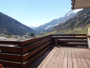 A wooden deck with a view of a valley and mountains. - Olympia 54 # 2-bed apartment, Dusche, WC 2-Bettwohnung, Dusche, WC by Interhome (Leukerbad)