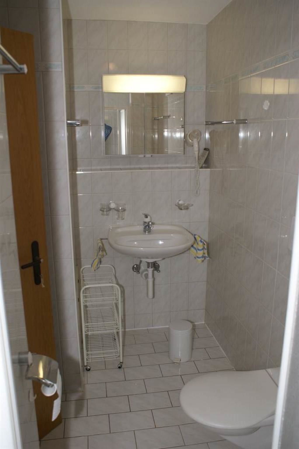 Une petite salle de bain comprenant des toilettes, un lavabo et un espace douche.