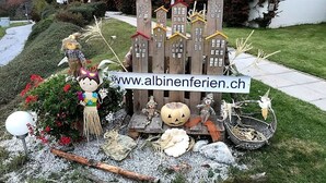 A Halloween-themed display with a wooden house, scarecrow, and various decorations. - Albina 43 # 4-bed apartment, Dusche, WC 4-Bettwohnung, Dusche, WC by Interhome (Albinen)