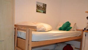 A bunk bed with a pillow and a green plush toy on the top bunk. - Albina 43 # 4-bed apartment, Dusche, WC 4-Bettwohnung, Dusche, WC by Interhome (Albinen)