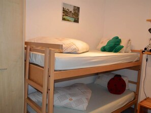 A bunk bed with a pillow and a green plush toy on the top bunk. - Albina 43 # 4-bed apartment, Dusche, WC 4-Bettwohnung, Dusche, WC by Interhome (Albinen)
