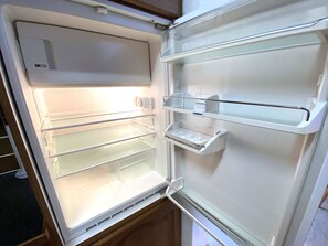 An open refrigerator with multiple shelves and a water dispenser. - Lärchenwald 1706 # 6-bed apartment, Dusche, WC 6-Bettwohnung, Dusche, WC by Interhome (Leukerbad)