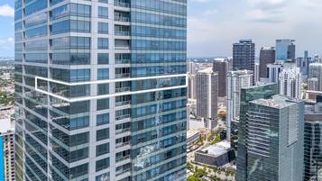 A high-rise building with a modern glass facade, surrounded by other tall buildings in a cityscape.