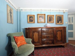 A room with a green armchair, a wooden cabinet with multiple drawers, and a patterned carpet. - Heimatkunst 1 (Lucia) # 5-bed apartment, Dusche, WC 5-Bettwohnung, Dusche, WC by Interhome (Leukerbad)