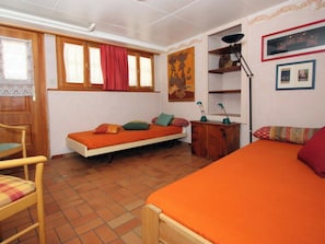 Una camera spaziosa con un letto, una scrivania e una sedia.