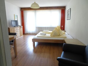 A hotel room with a bed, a desk, a chair, and a television. - Leuca 31 # 2-bed apartment, Dusche, WC 2-Bettwohnung, Dusche, WC by Interhome (Leukerbad)