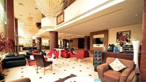 A spacious lobby with a high ceiling, multiple seating areas, and a reception desk. - Junior Twin Peaceful Stay in Millnia (Riyadh)