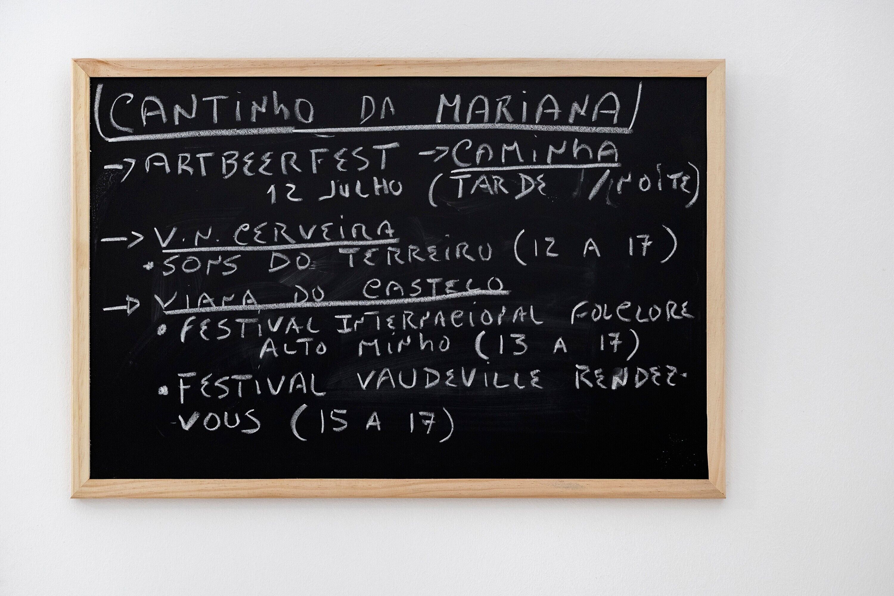 A blackboard with chalk writing listing events and dates.
