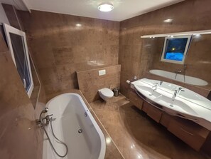 Ein modernes Badezimmer mit einer freistehenden Badewanne, einem Doppelwaschbecken und einer Toilette.