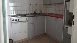 A compact kitchen with a stove, sink, and cabinets. - Fortuna 201 # 4-bed apartment, Dusche, WC 4-Bettwohnung, Dusche, WC by Interhome (Leukerbad)