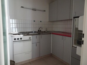 A compact kitchen with a stove, sink, and cabinets. - Fortuna 201 # 4-bed apartment, Dusche, WC 4-Bettwohnung, Dusche, WC by Interhome (Leukerbad)