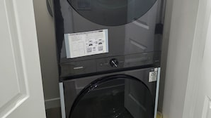 Een Samsung was- en droogcombinatie met energielabel 608 kWh, installatiehandleiding en een kortingshanger van 20%.