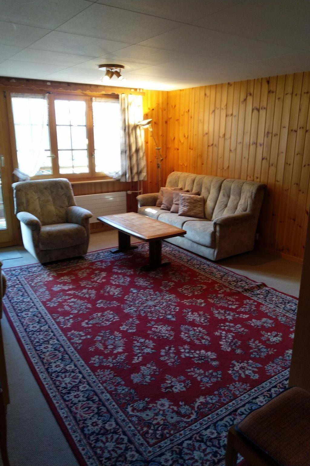 Ein Wohnzimmer mit Sofa, Sessel und Couchtisch.