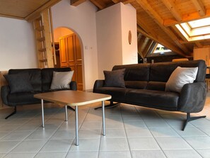 A modern living room with two sofas, a coffee table, and a wooden ceiling. - Edelweiss B 42 # 6-bed apartment, Dusche und Bad, WC by Interhome (Leukerbad)