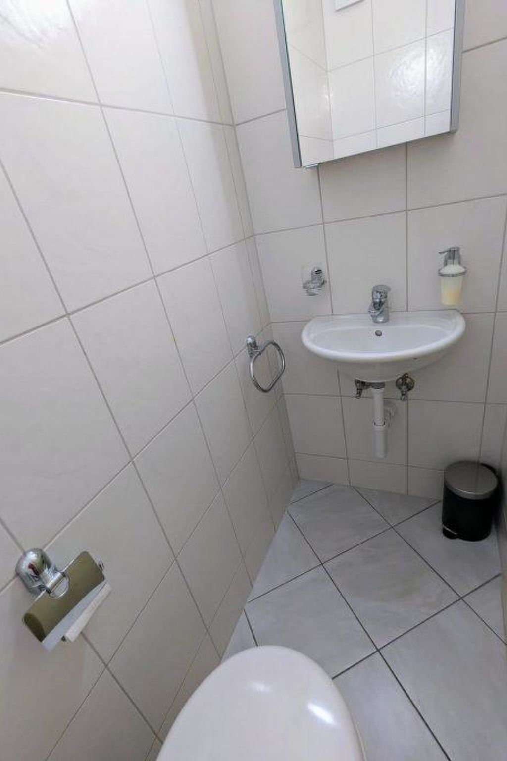 Une salle de bain avec des toilettes, un lavabo et un miroir.