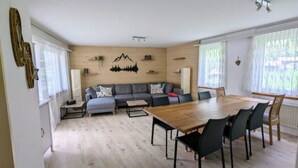 Una sala de estar moderna con un sofá, una mesa de comedor y una zona de cocina.