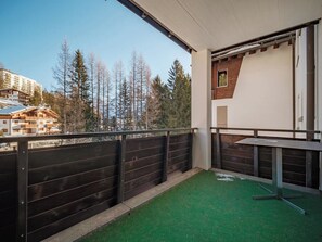 A balcony with a view of trees and buildings, a wooden fence, and a green artificial turf. - Brüggli A14 Appartement/Fewo, Bad, WC, 4-Bettwohnung by Interhome (Arosa)