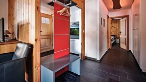 Eine moderne Küche mit roter Akzentwand, Holzvertäfelung und einer Edelstahl-Dunstabzugshaube.