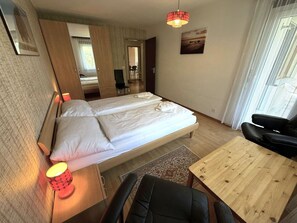Een hotelkamer met een bed, een bureau, een stoel, een tafel en een televisie.