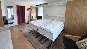 Una camera da letto moderna con un letto, una scrivania e una sedia.
