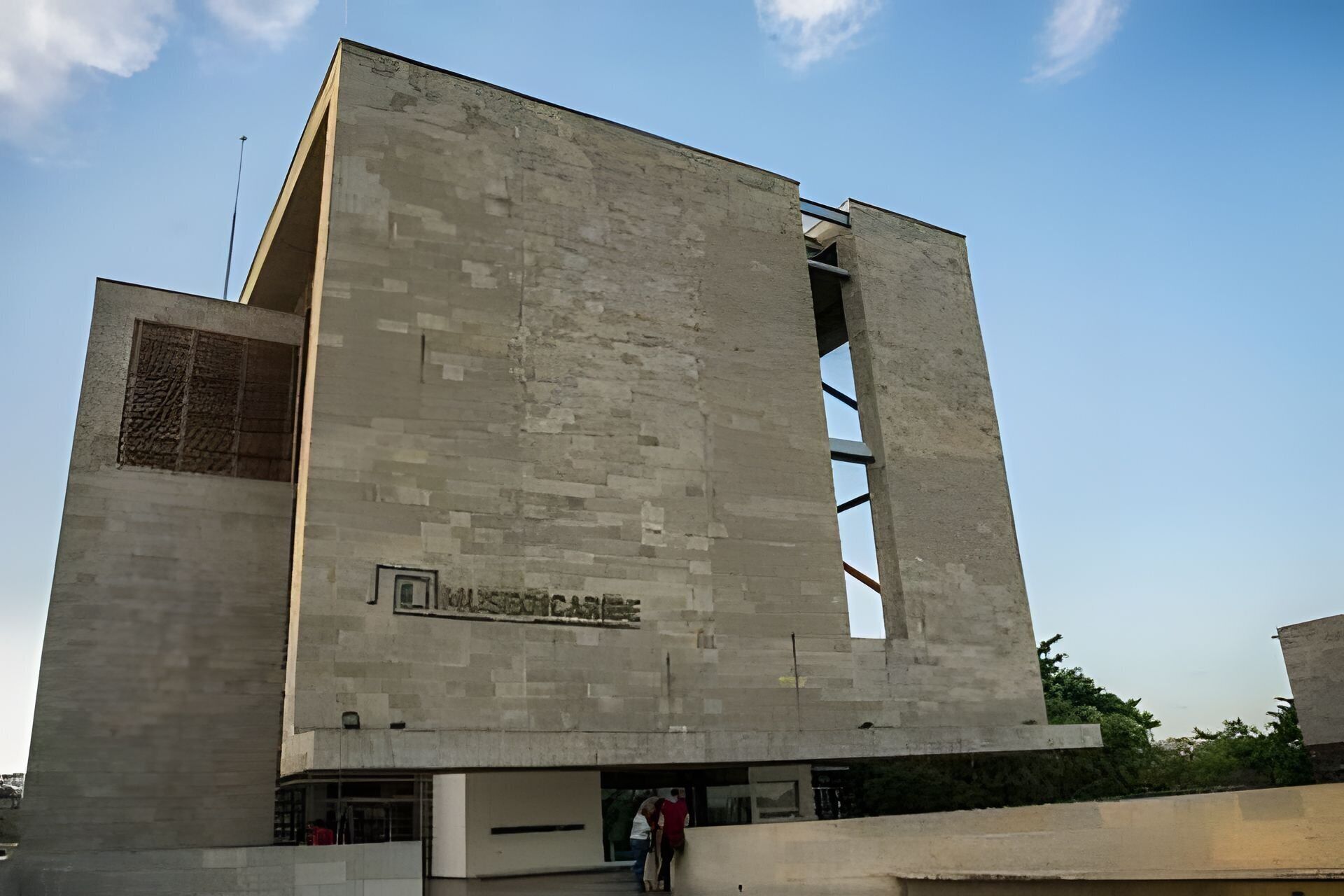 A modern building with a flat facade and a large open entrance.