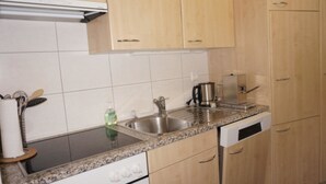A kitchen with a stainless steel sink, a coffee maker, and a dishwasher. - Paradies 017 Appartement/Fewo,   4-Bettwohnung by Interhome (Arosa)