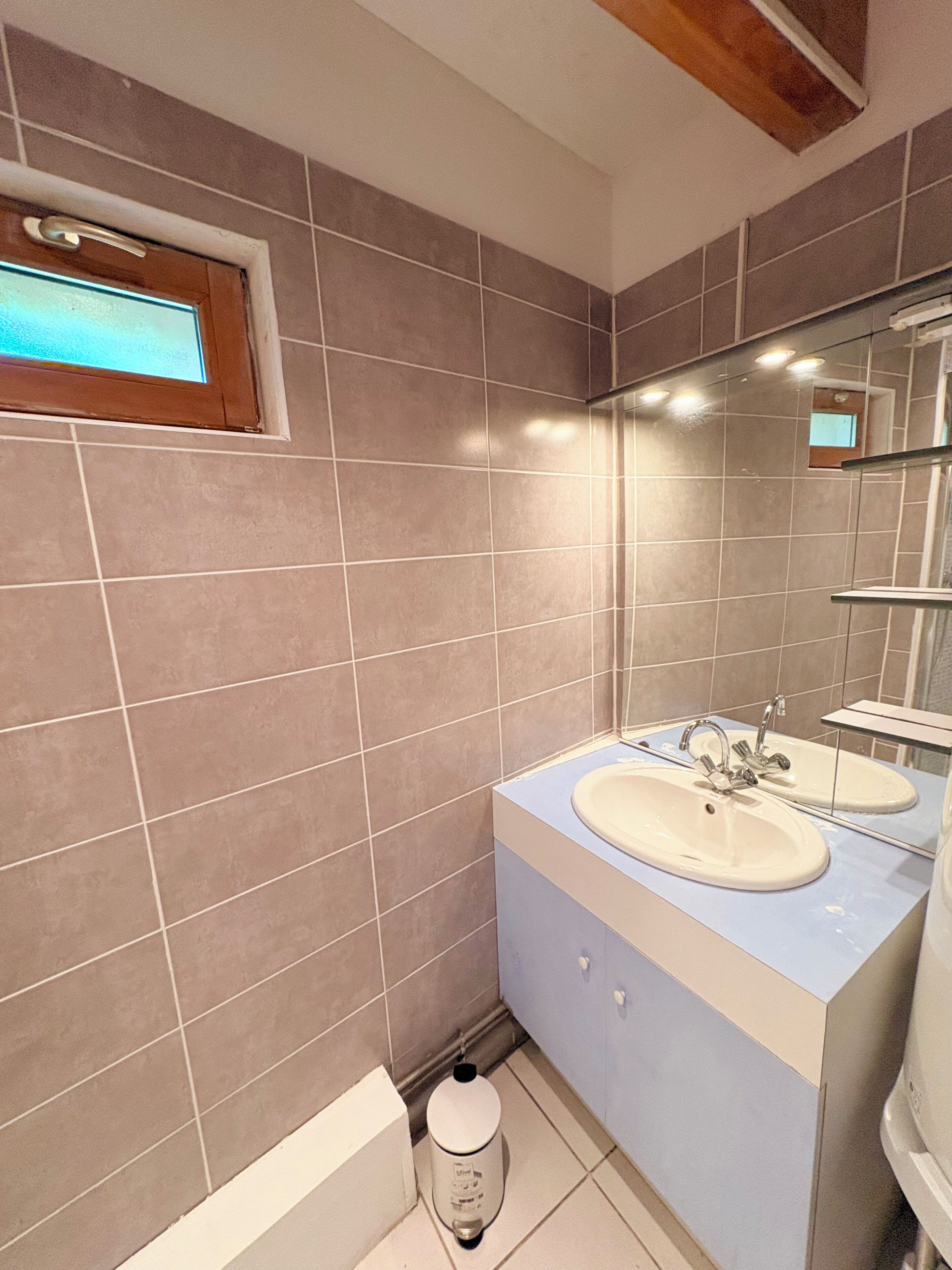 A bathroom with two sinks, a window, and a toilet.